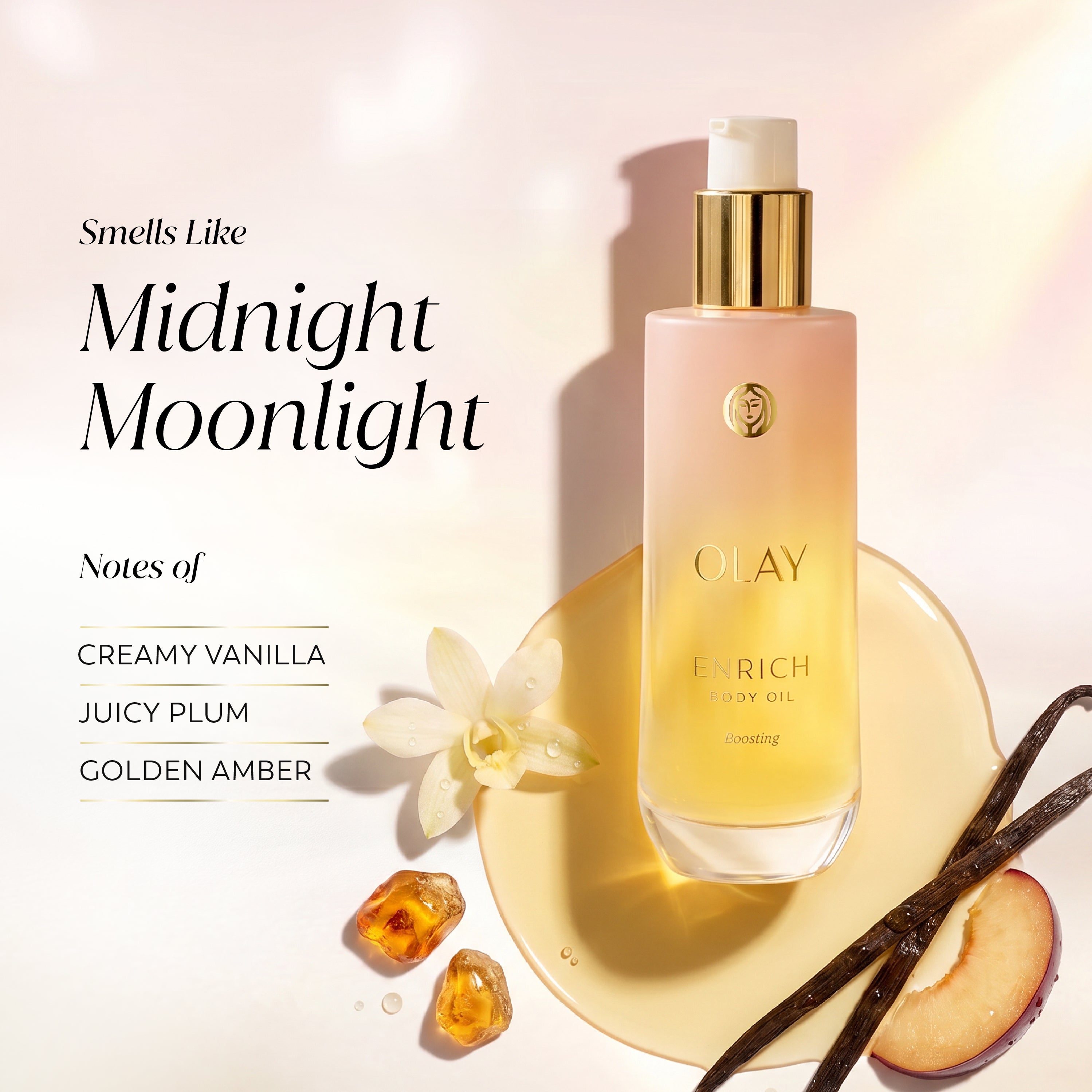 Olay Enrich Body Oil in the 'Smells Like Midnight Moonlight' scent, shown in a frosted bottle with a gold pump, styled on a gold plate with vanilla beans, a peach slice, and amber crystals against a warm cream background.