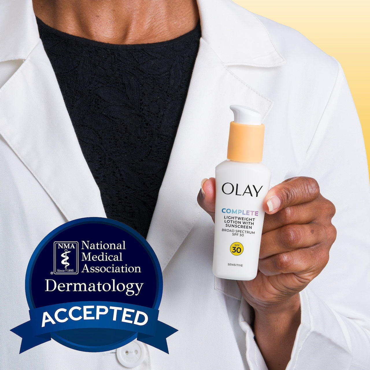 Model wearing lab coat holding Olay Complete Lotion Moisturizer with SPF 30 Sensitive bottle. National medical association dermatology accepted.