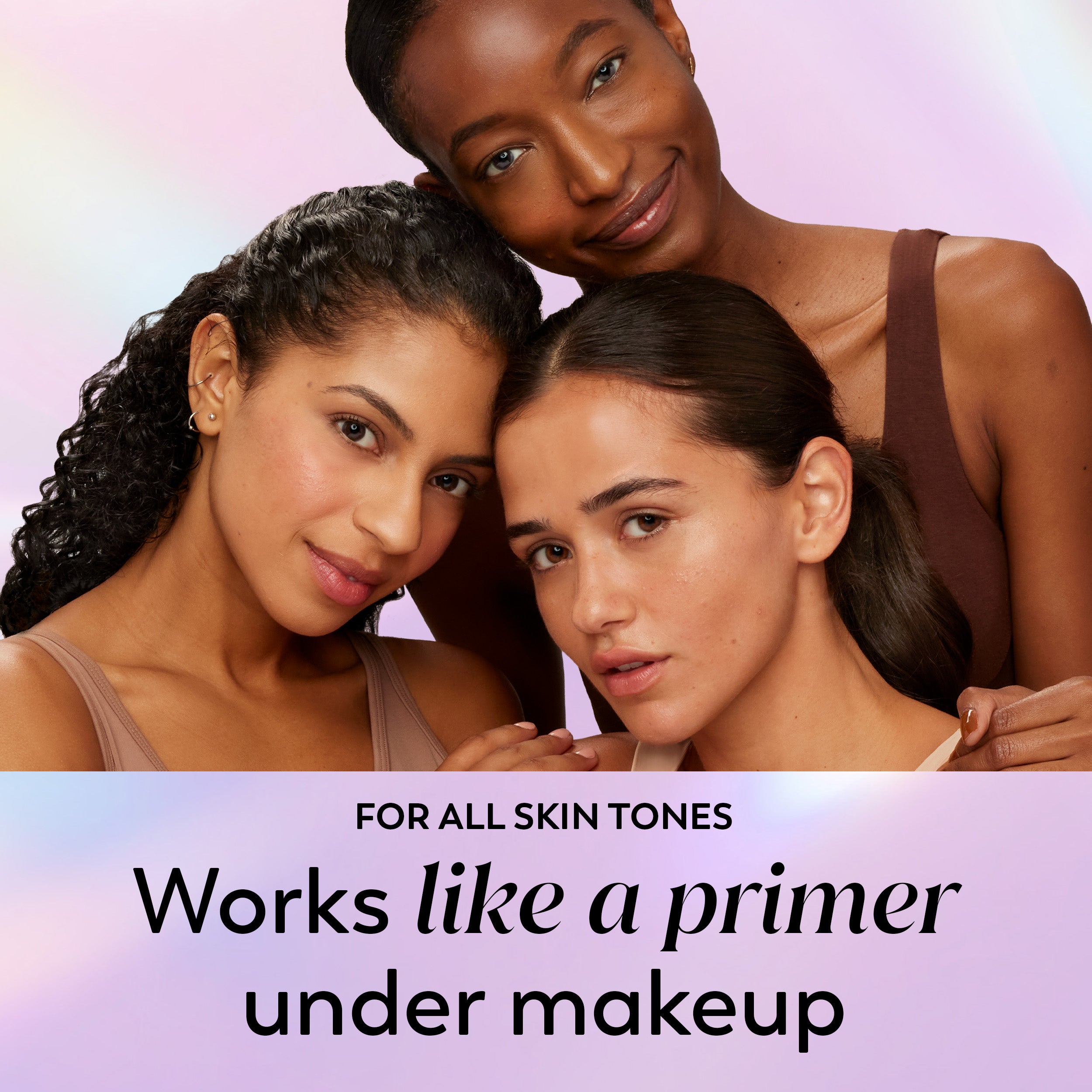 Three women with clean, makeup-free skin pose together against a soft pink and purple gradient background. Text at the bottom reads 'FOR ALL SKIN TONES Works like a primer under makeup.