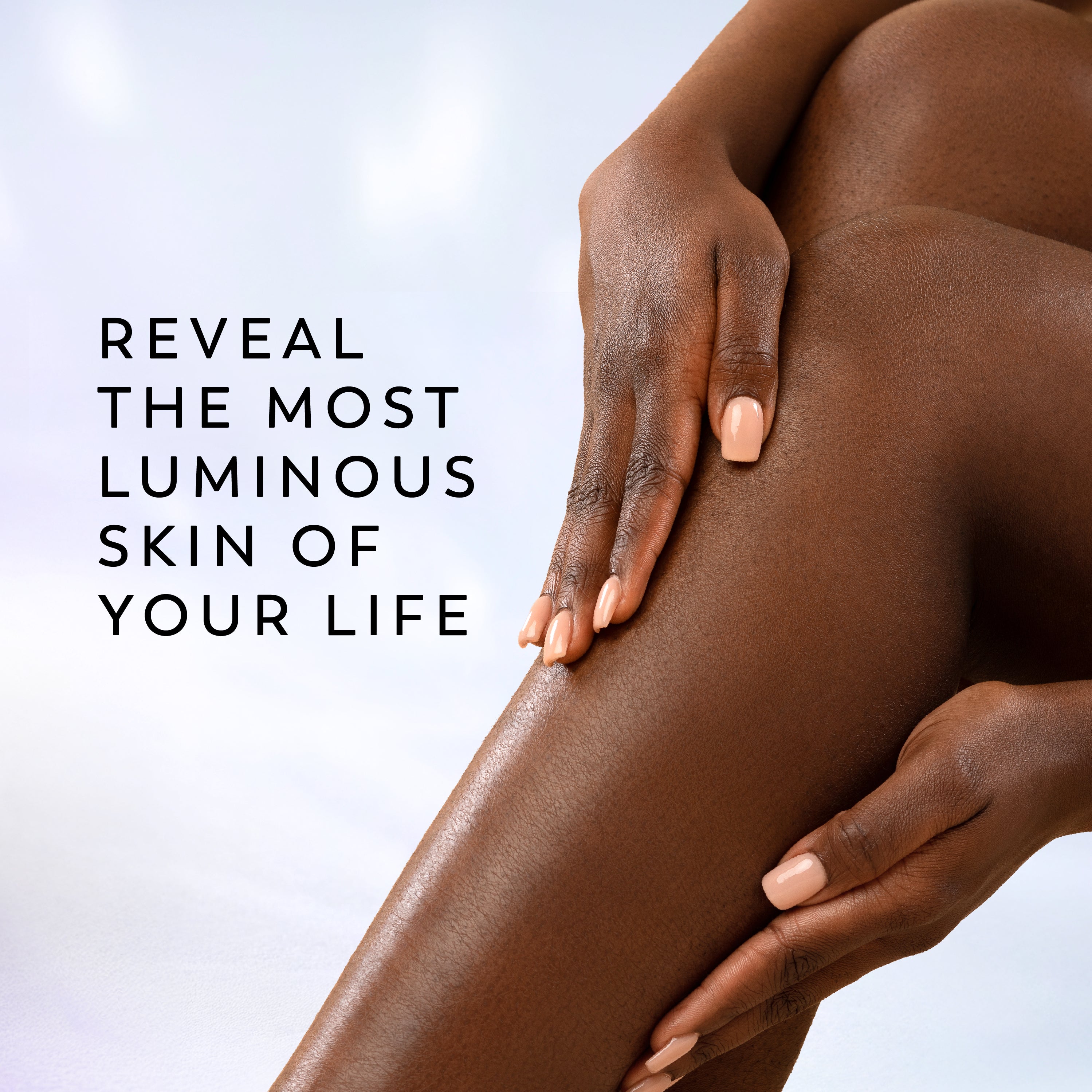 Close-up of a person's hands and thigh with smooth, luminous skin against a soft light background, with the text 'REVEAL THE MOST LUMINOUS SKIN OF YOUR LIFE' on the left.