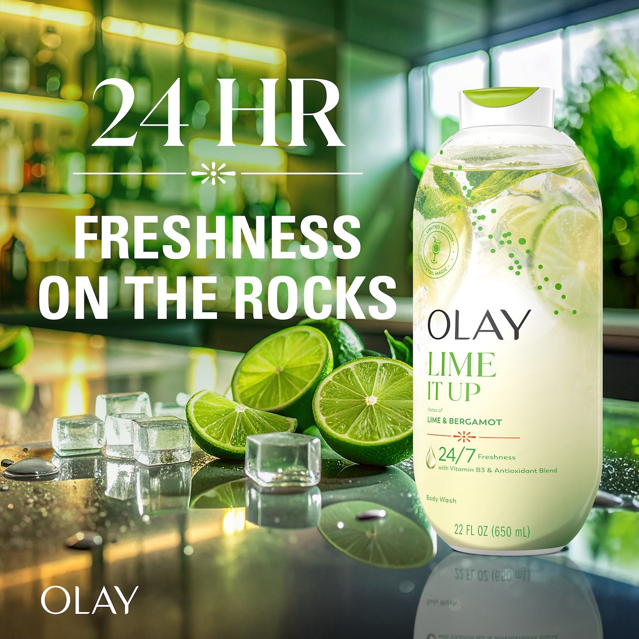Olay Lime It Up Body Wash with Notes of Lime and Bergamot, Vitamin B3 and Antioxidant Blend, 22oz on counter top of bar. 24 hour freshness on the rocks