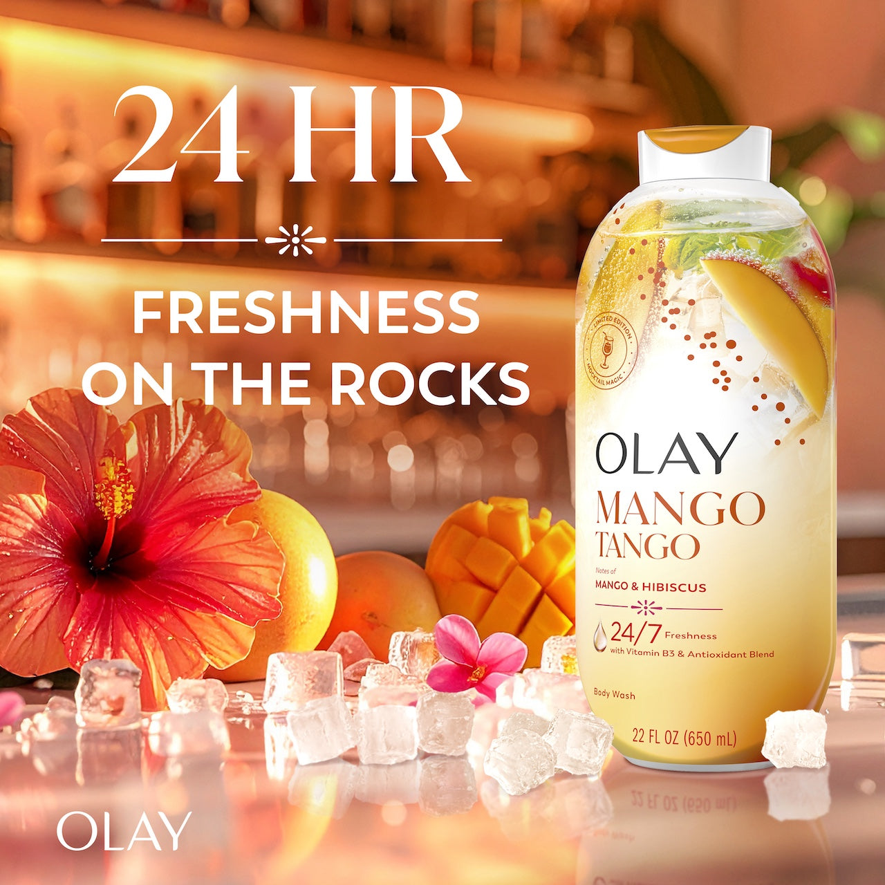 Olay Mango Tango Body Wash with Notes of Mango and Hibiscus, Vitamin B3 and Antioxidant Blend, 22oz on a counter top. 24 hours freshness on the rocks