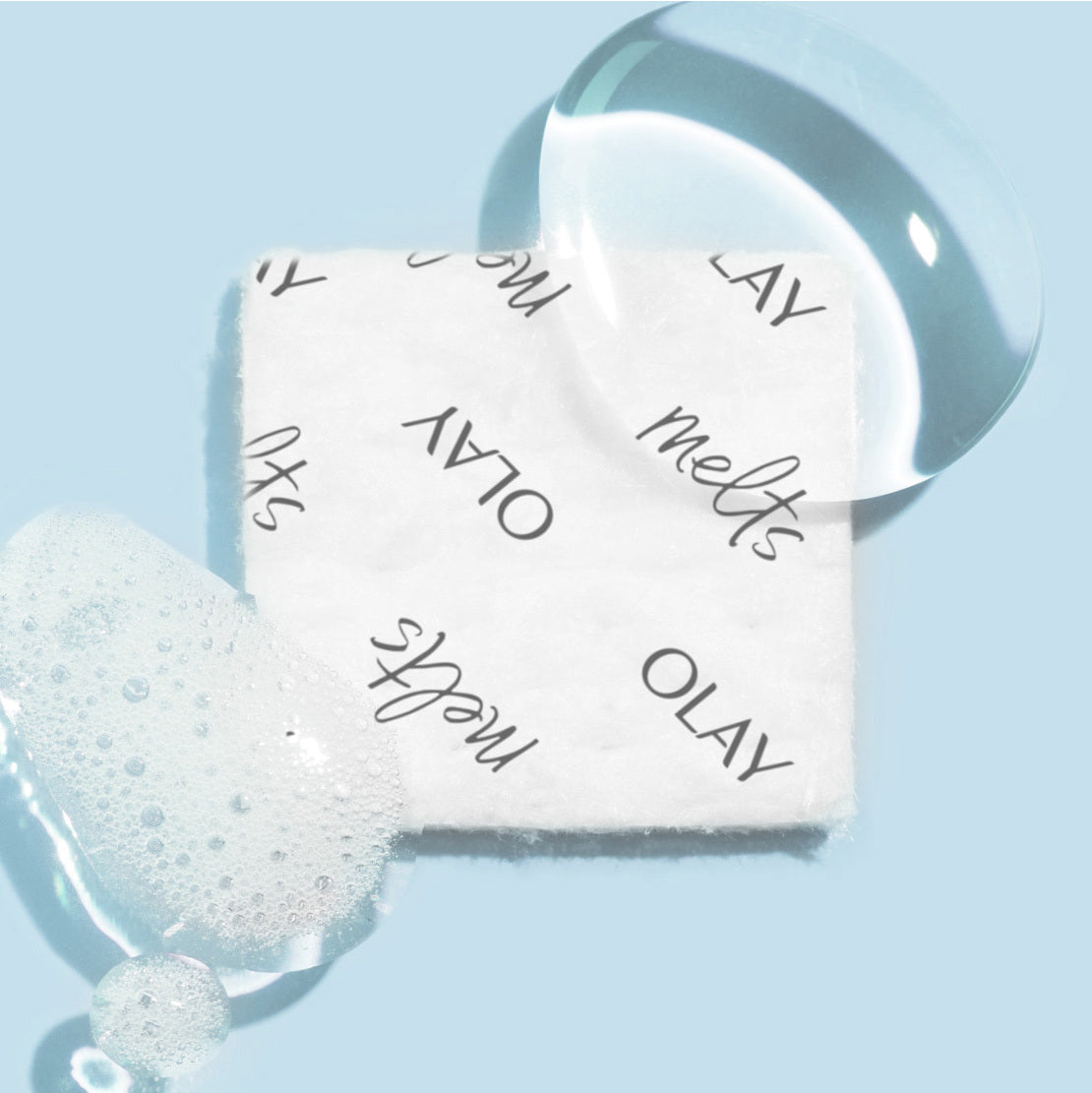 Olay soap bar with a sponge on a light blue background