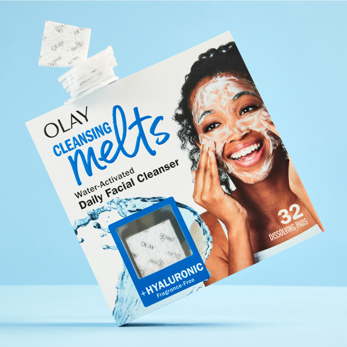 Olay Cleansing Melts packaging with a woman applying the product on a blue background