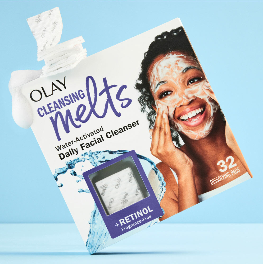 Olay Cleansing Melts packaging with a woman applying the product on a blue background