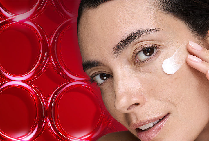 Woman applying cream to her face with a red circular pattern in the background