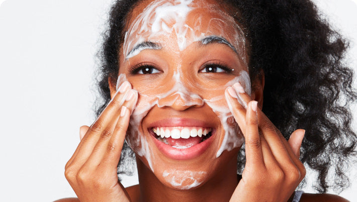 Woman applying a facial mask with a white background