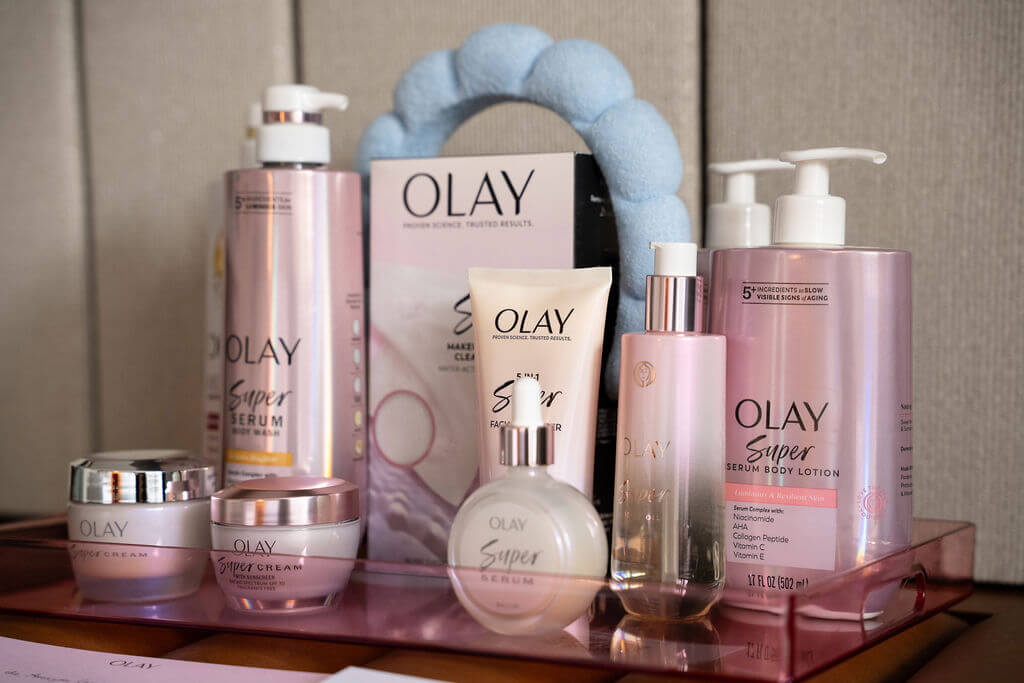 Olay skincare and body care products arranged on a pink display.