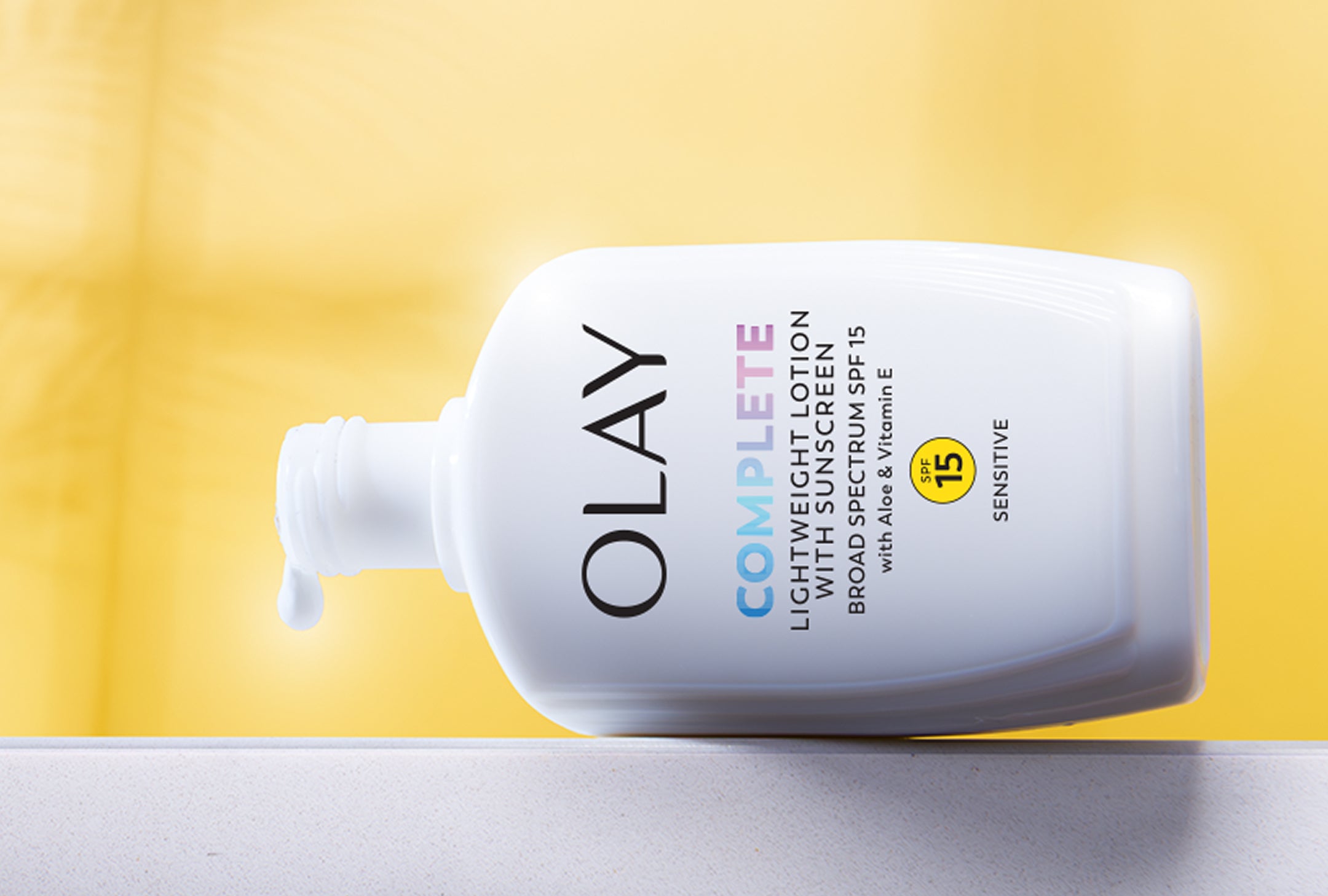 Olay Complete Lotion bottle on a yellow background
