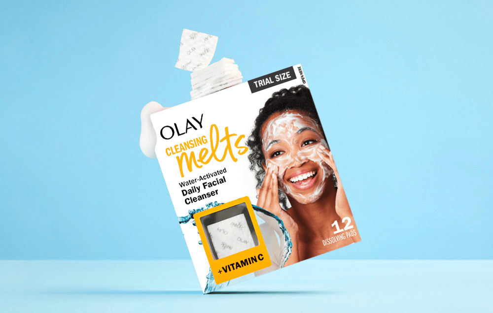 Olay Cleansing Melts packaging with a woman applying product on a blue background