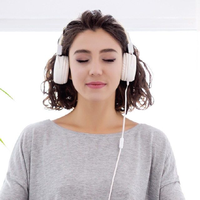 Woman in meditation listening to music on headphones